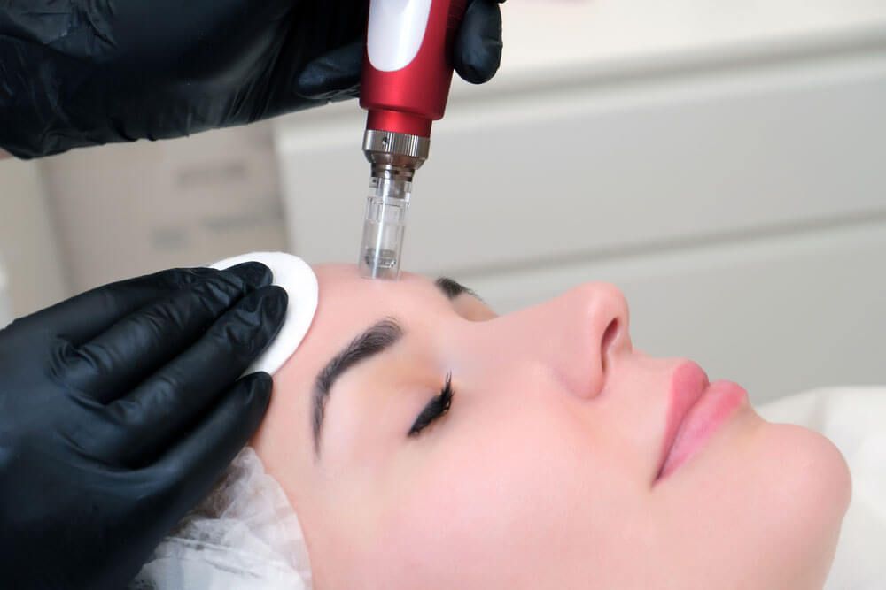 Cosmetologist performs needle mesotherapy on a womans face