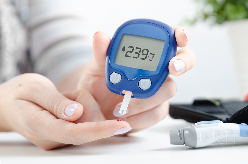 Woman use glucometer checking blood sugar level