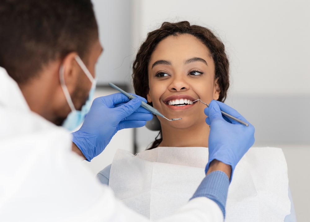 lady in dentist chair looking at her doctor