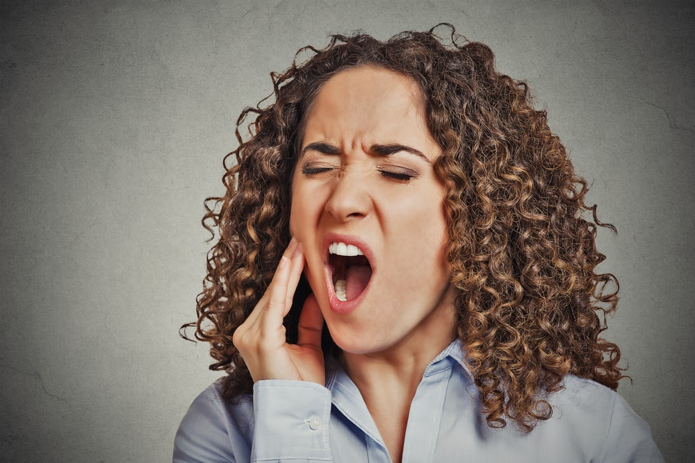 young woman with sensitive tooth ache