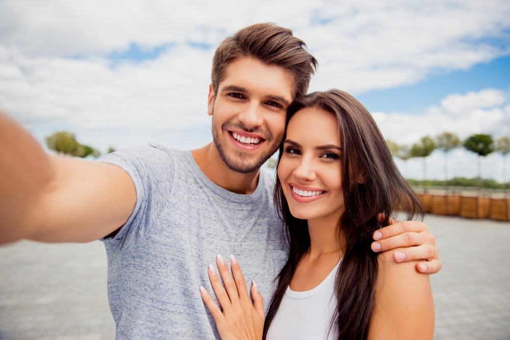 Loving cheerful happy couple taking selfie