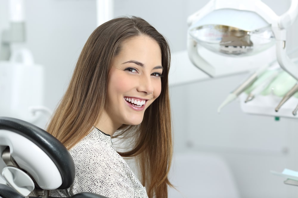 Patient showing her perfect smile after treatment in a clinic