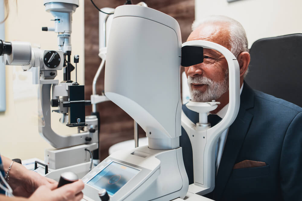 Elegant senior bearded man receiving ophthalmology treatment.