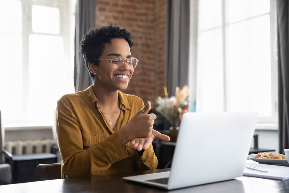 Smiling friendly African American therapist in glasses talking on video call