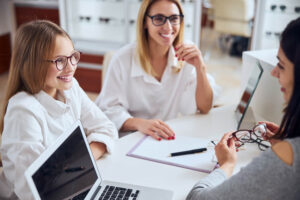 Happy cheerful mother with teenager daughter sitting at the doctor