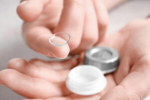 Woman holding contact lens and case, closeup