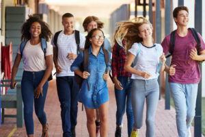 Teenager school kids running in high school hallway