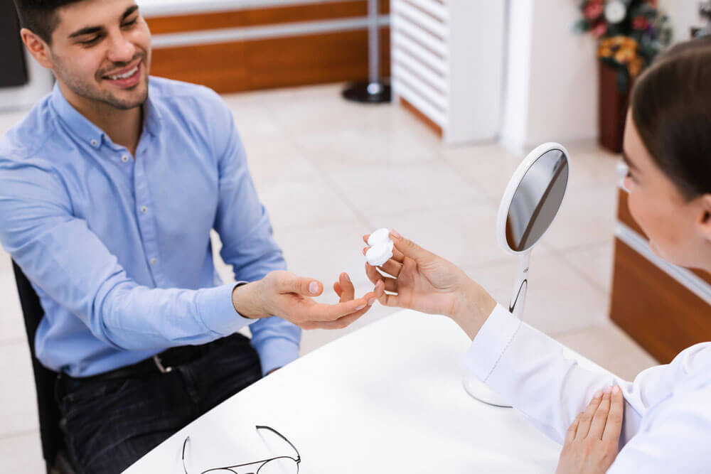 Female doctor optometrist giving plastic container