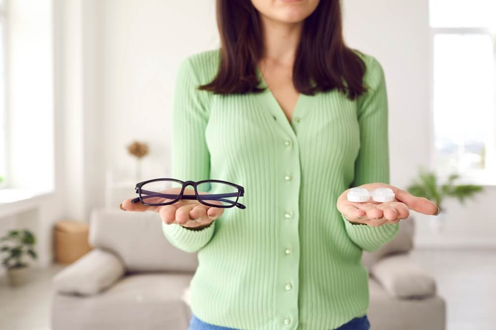 Woman making choice between glasses and eye lenses