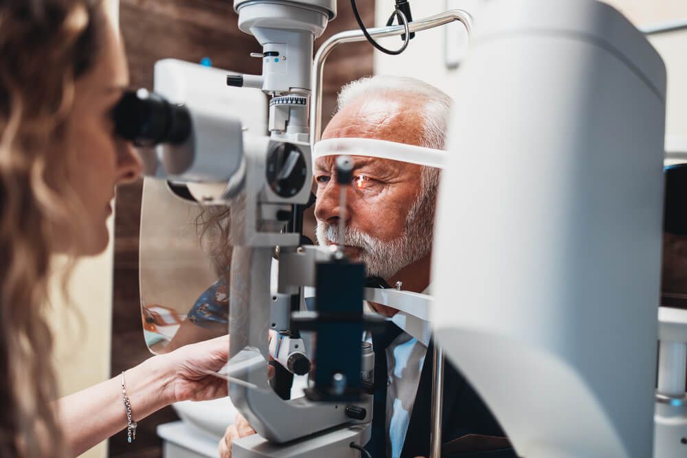 Elegant senior bearded man receiving ophthalmology treatment.