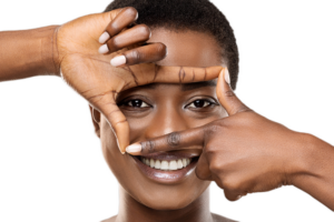 Beautiful African woman holding frame from fingers near her eyes