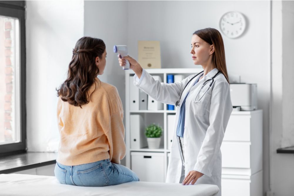 female doctor with infrared forehead thermomete