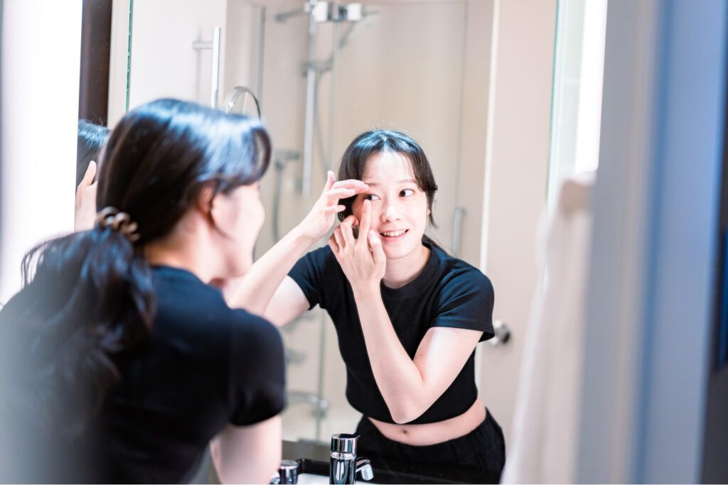 Young woman putting on contact lenses