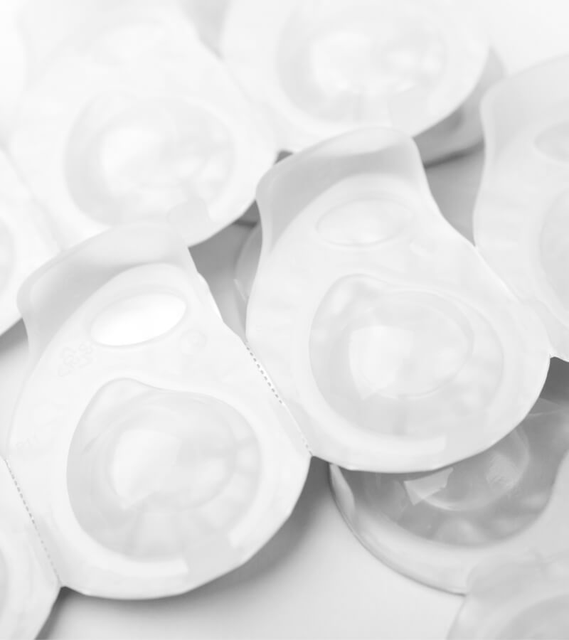 Several packs of contact lens on white surface.
