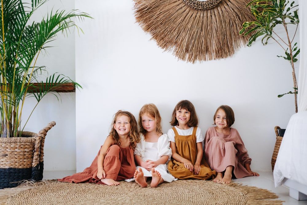 Four happy little girls about the same age are sitting on the floor
