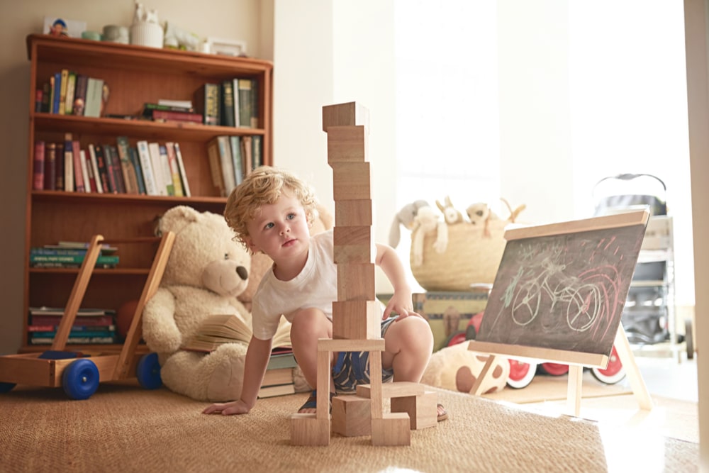 Shot of an adorable little boy playing with wooden blocks at home.