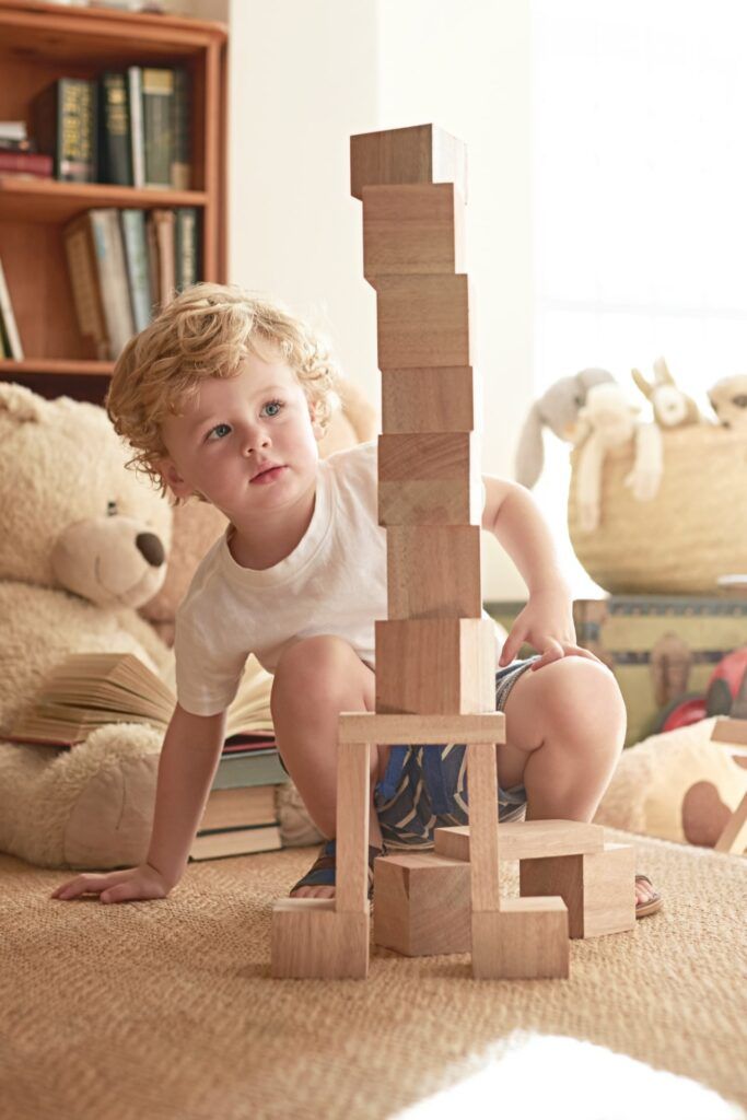 Shot of an adorable little boy playing with wooden blocks at home.