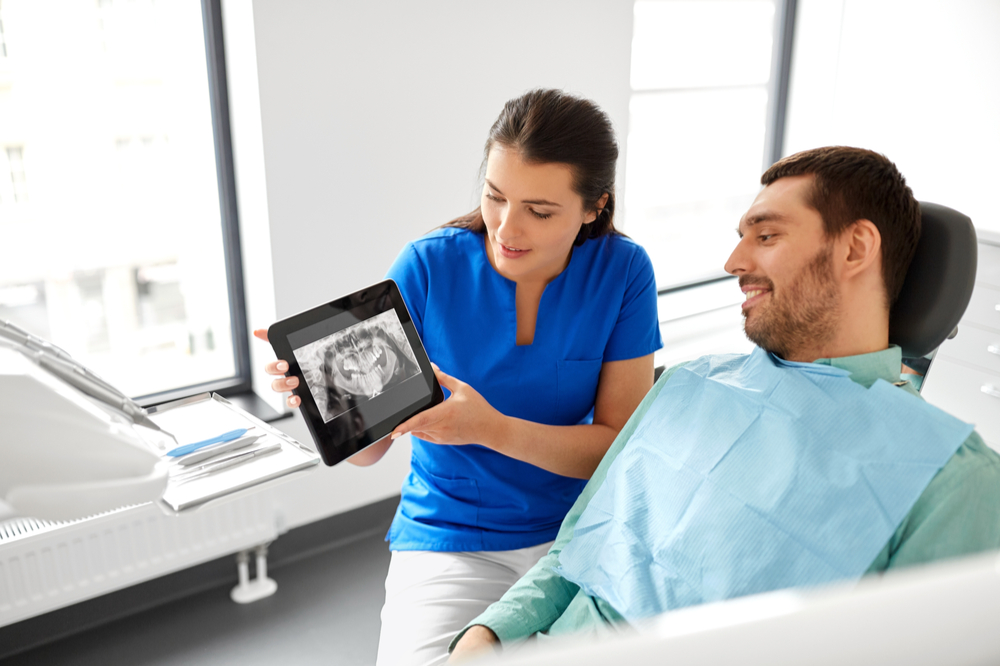 Female dentist showing teeth panoramic x-ray scan