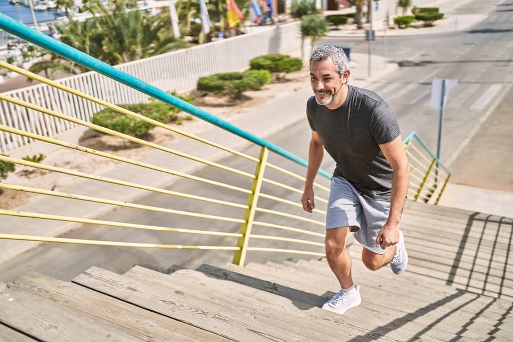 Middle age hispanic man wearing sportswear running at street