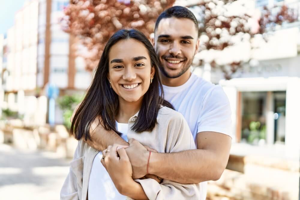 Young latin couple smiling happy and hugging at the city.