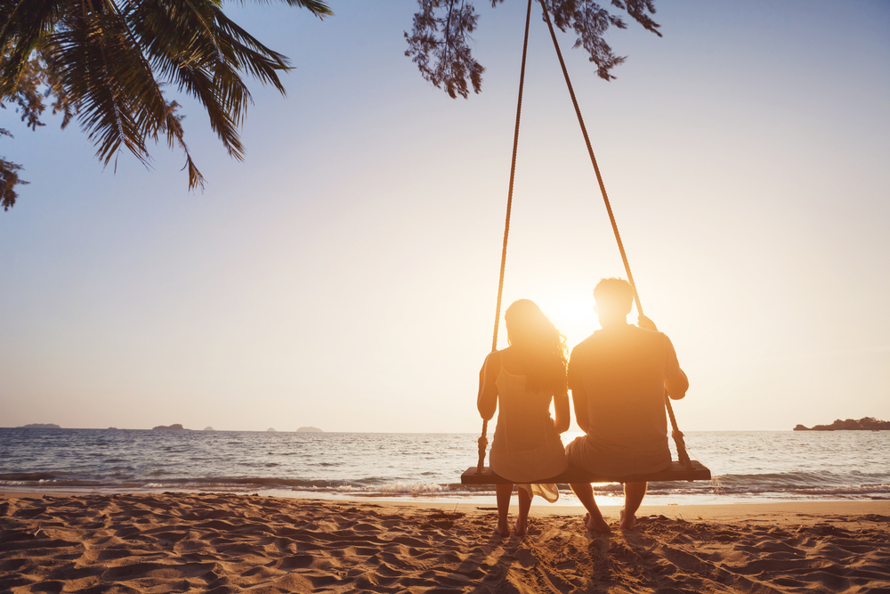 Romantic Couple In Love Sitting Together On Rope Swing At