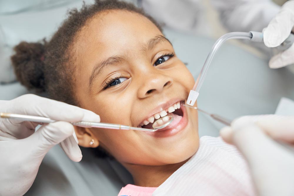 Charming little girl sitting in dental chair, smiling