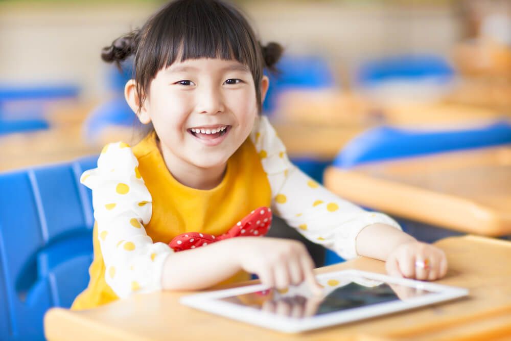 smiling kid using tablet or ipad