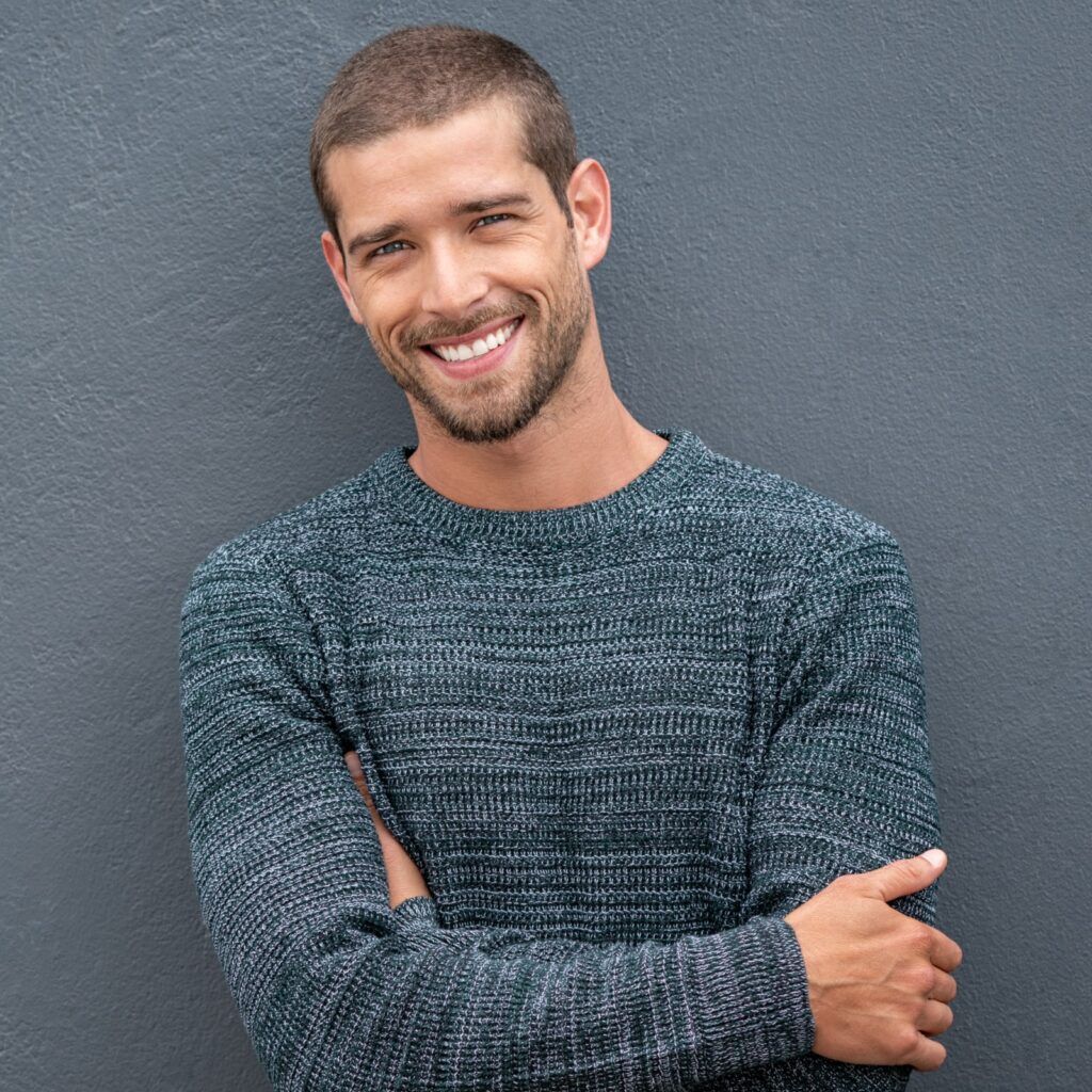 happy young man leaning against wall