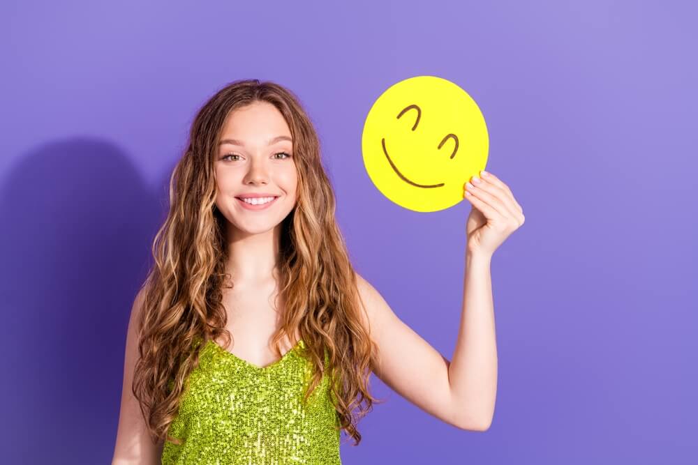 attractive teen woman hold emoji smile paper dressed stylish green