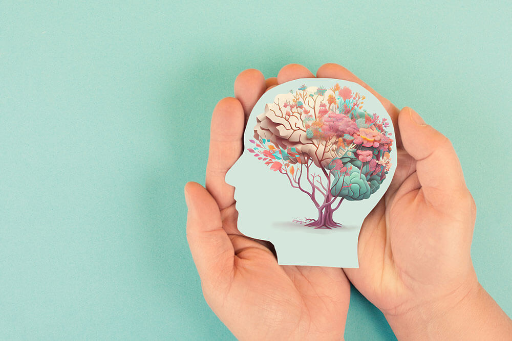 Hands holding head, human brain with flowers