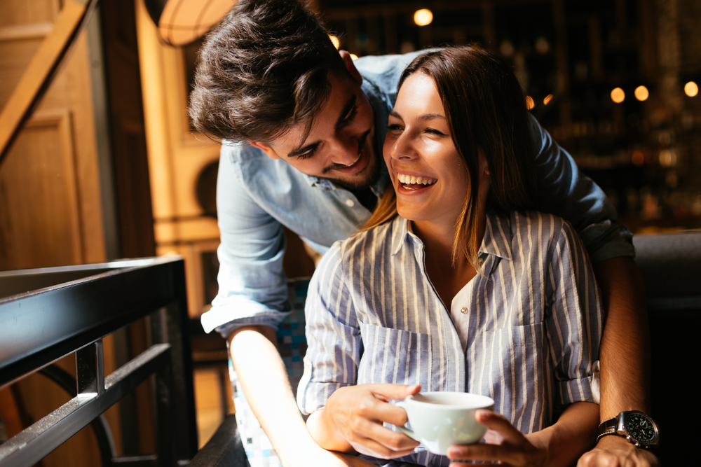 Young attractive couple on date in coffee shop