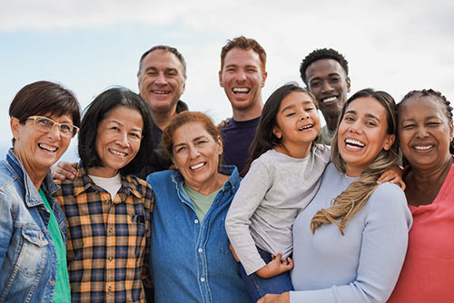 Group of multigenerational people hugging each other while smiling