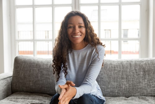 Beautiful young women smiling sitting on sofa