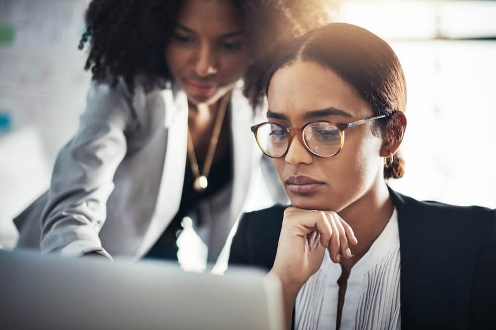 Two women working together on a laptop