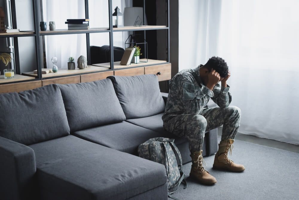 soldier in military uniform suffering from PTSD at home