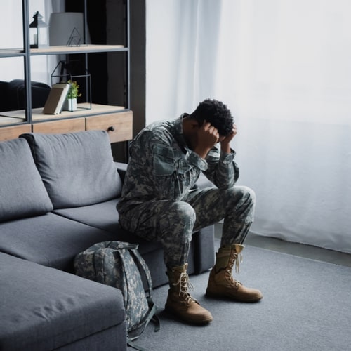 soldier in military uniform suffering from PTSD at home