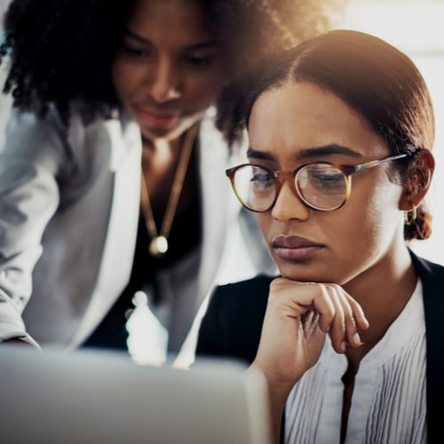 Two women working together on a laptop