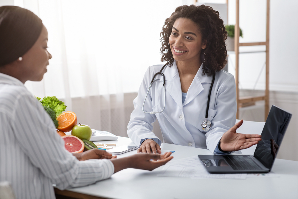 Smiling Female African Doctor Nutritionist Having Conversation With Her Patient