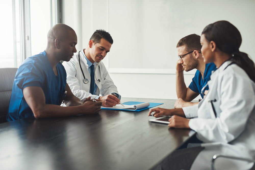 Multiracial Medical Team Having A Meeting With Doctors In White