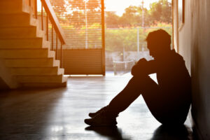 Silhouette Of Sad Depressed Insomnia Man.sitting Against Sunset.