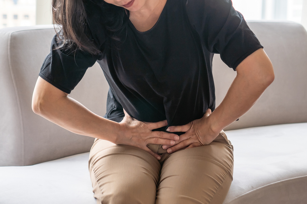 Abdominal pain in woman with stomachache illness from menstruation cramps