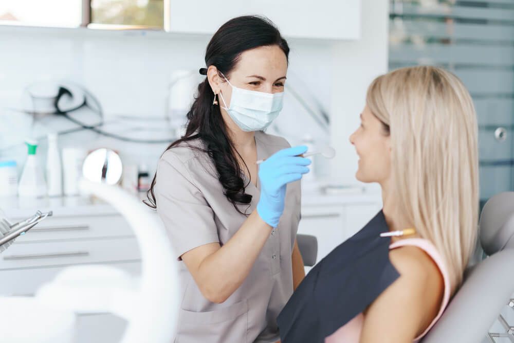 Female Dentist examine and discussing with happy patient about treatment