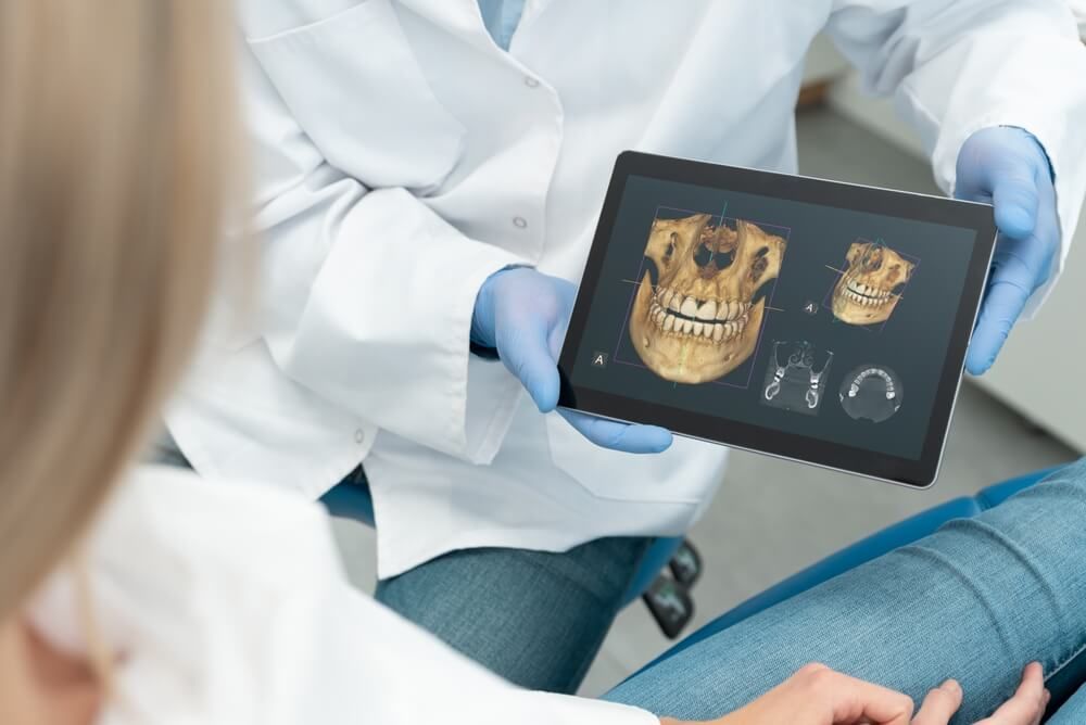 Dentist showing teeth x-ray on digital tablet screen