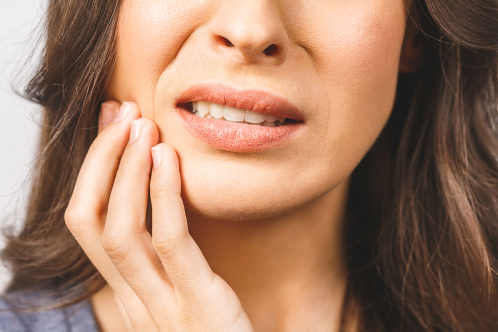 Young European woman isolated on white background suffering from severe toothache