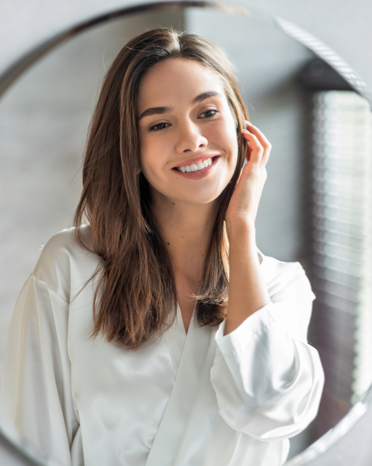 Portrait Of Attractive Happy Woman Looking At Mirror In Bathroom