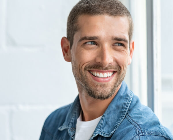 Confident young man looking away with big smile.