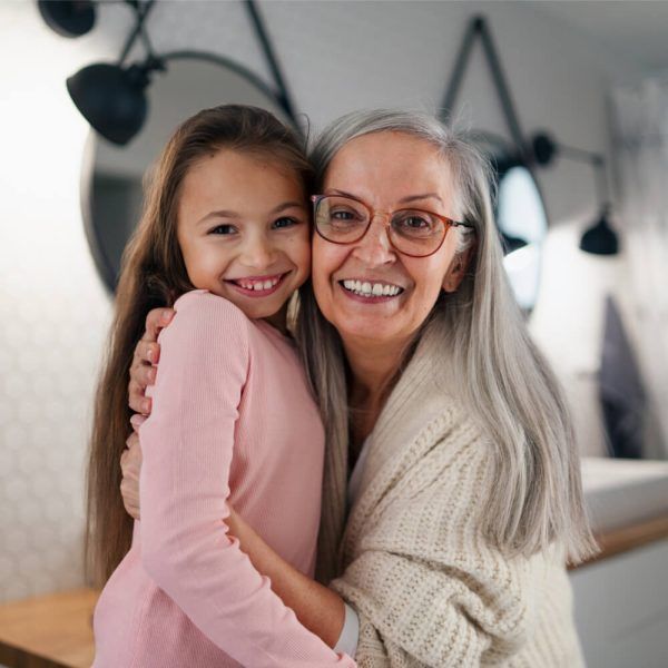 Senior grandmother and granddaughter standing indoors in bathroom