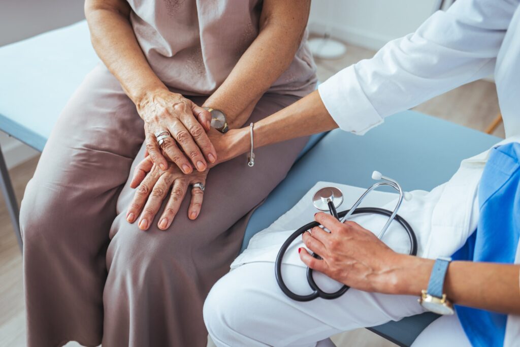 Health worker holding patient's hand. Senior woman holding hands with a nurse.