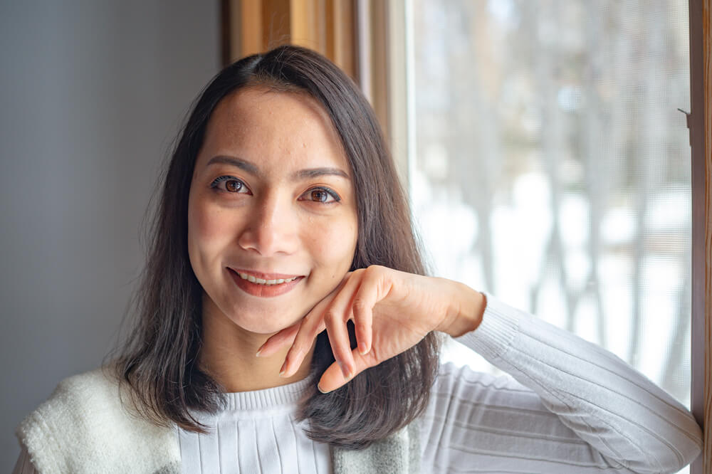 close Up Asian Young Woman smiling and looking at camera on Blurred Background.