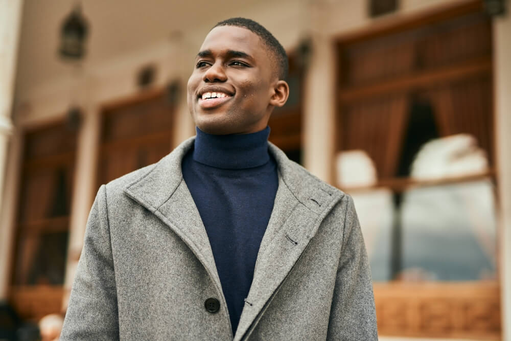 Young african american man smiling happy standing at the city